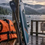 Activités nautiques vosges : gilet orange et paddle sur un quai au lac