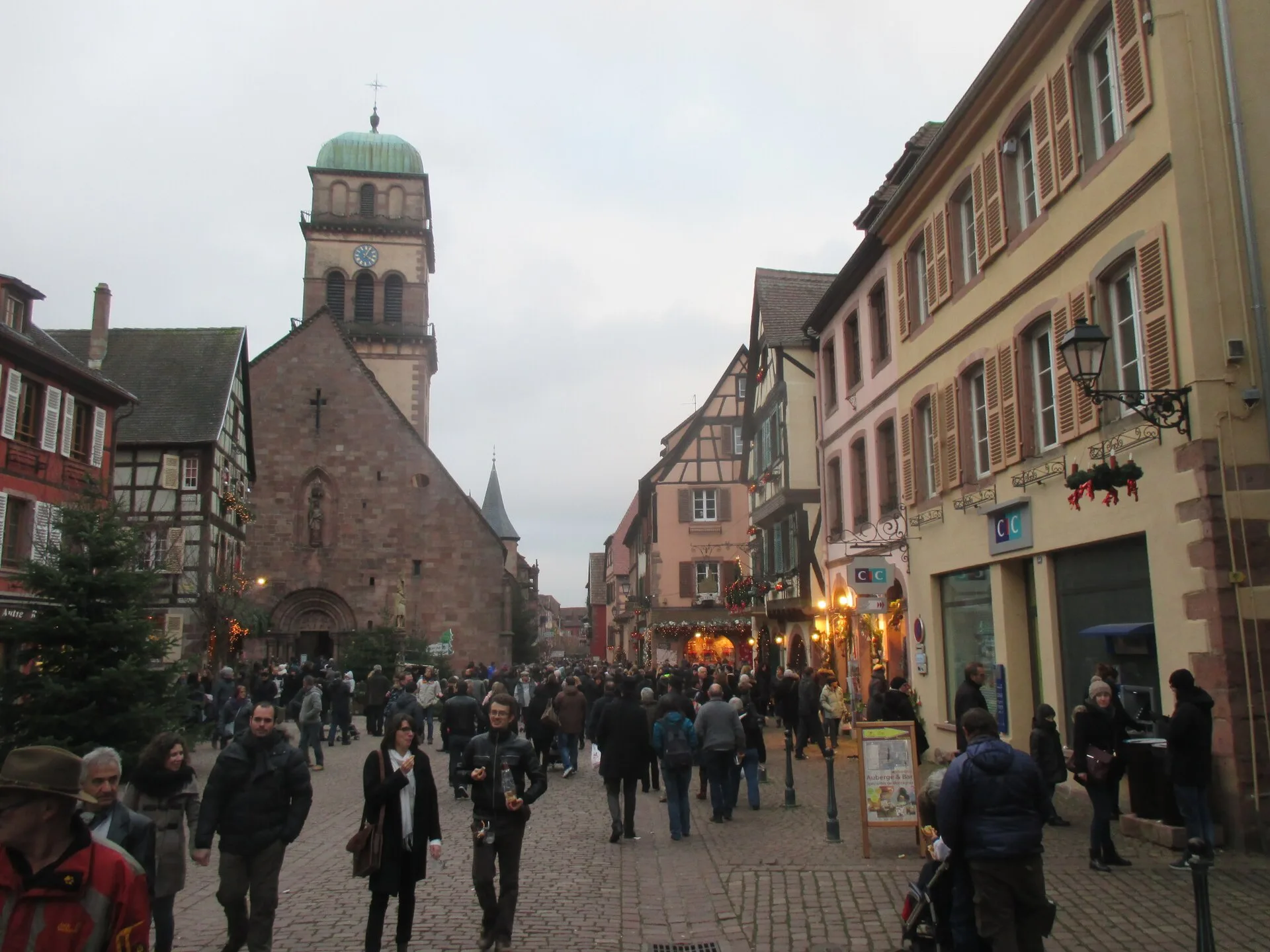 Rue de Kaysersberg animée pendant le marché de Noël, près de l’église Sainte-Croix
